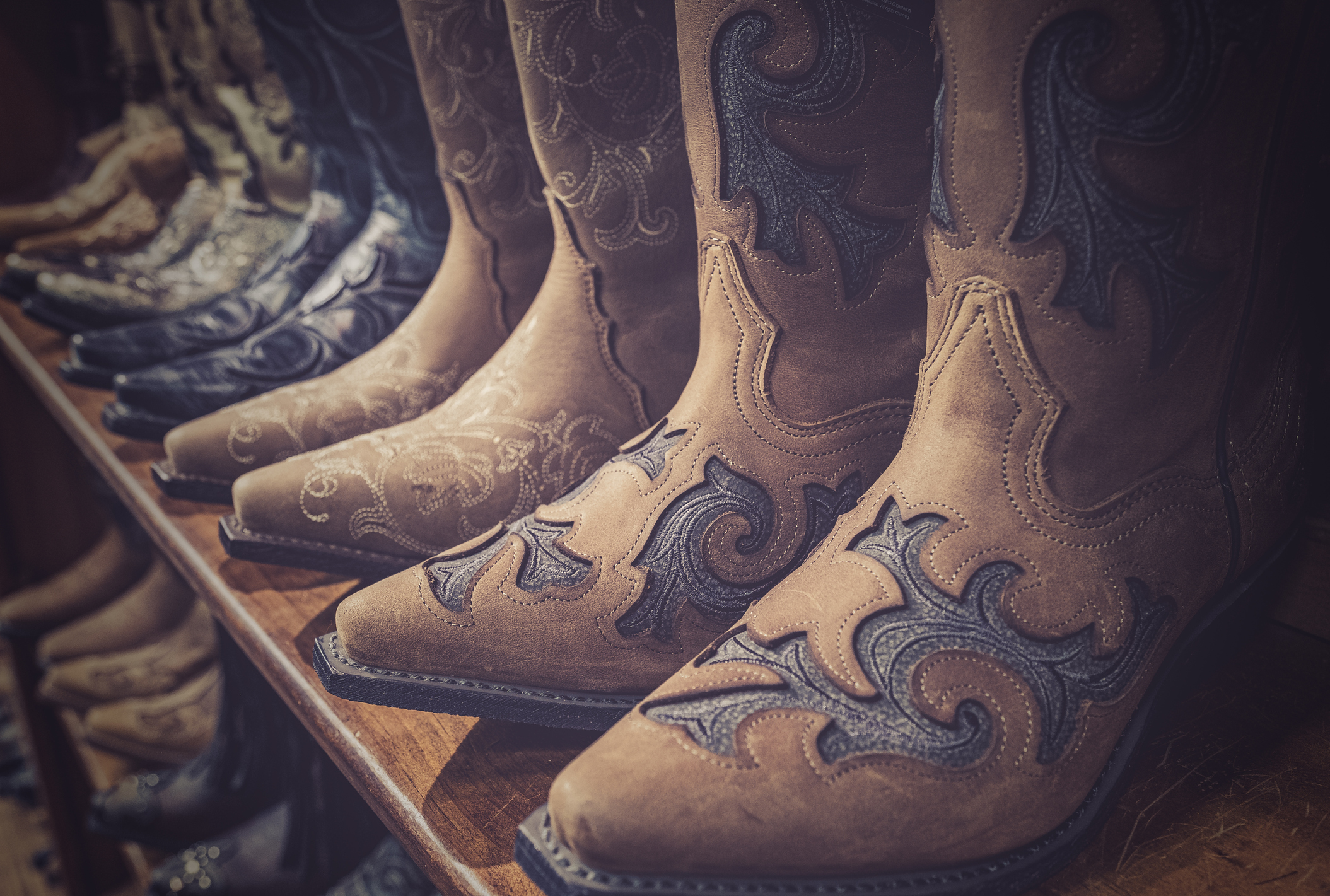 A closeup of brown leather Cowboy boots on sale on a shelf in a downtown Nashville, Tennessee Shop.