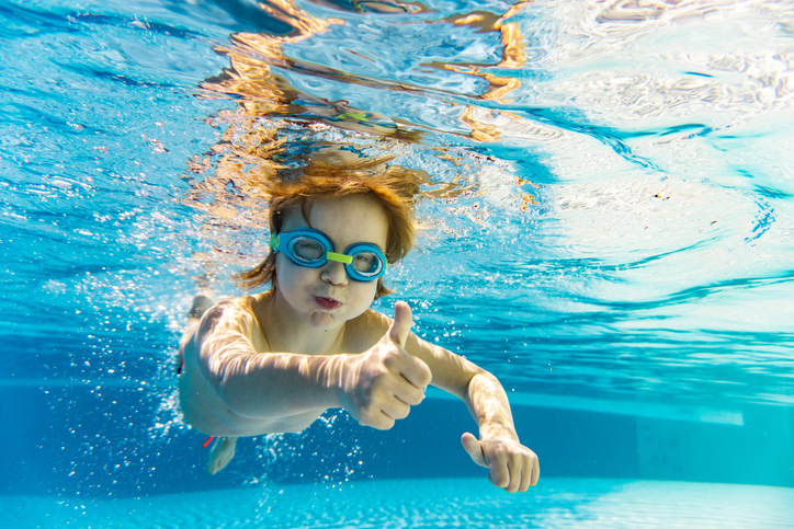 Smiling child giving a thumbs up in the outdoor pool at Residence Inn Nashville MetroCenter, a family-friendly hotel near downtown Nashville