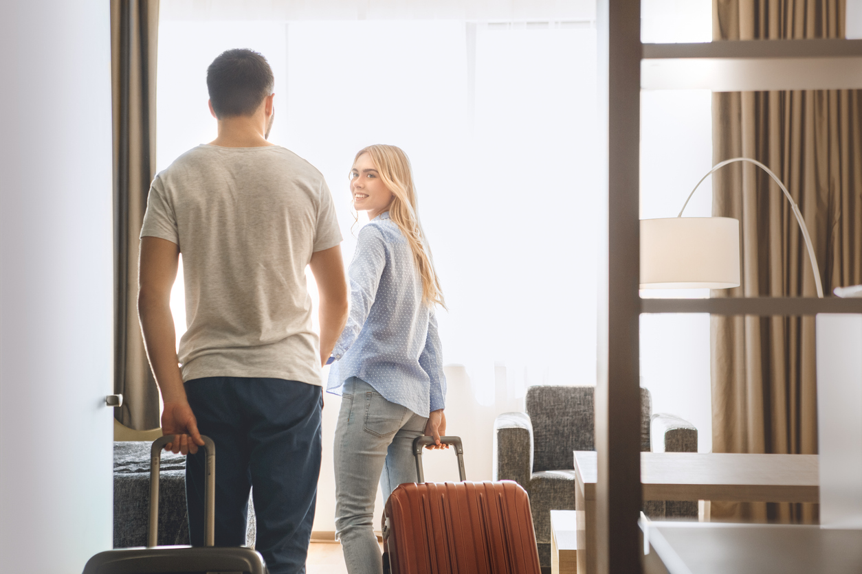 Couple arriving at their hotel with luggage